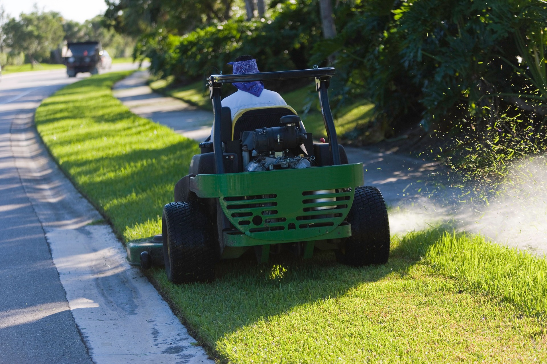 Man on lawn mower in the street